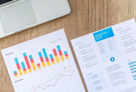Automated Data Analytics - Two White Printer Papers Near Macbook on Brown Surface