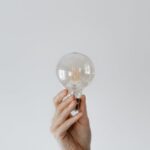 Smart Lighting - Anonymous female showing light bulb