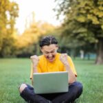 Approaches - Man Sitting on a Green Grass Field
