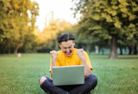 Approaches - Man Sitting on a Green Grass Field