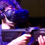 Virtual Reality Software - Man in VR with game riffle playing video game