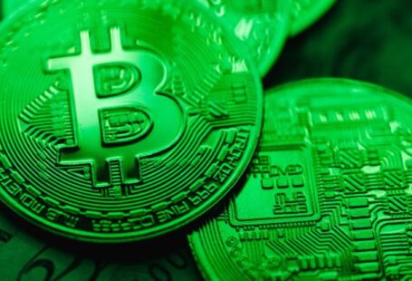 Blockchain Technology - Closeup of Bit Coins in a Green Light